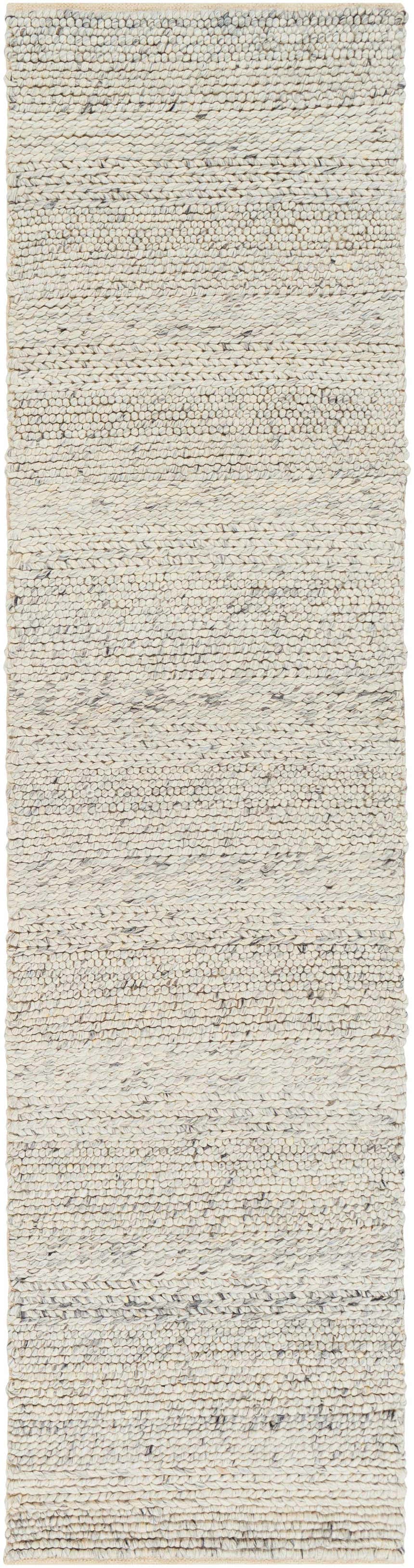 Close-up of the hand woven Salvo Luxury Wool Area Rug. Cream and black natural fiber rug with a subtle textured pattern. Design-Runner-2610