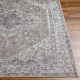 Close-up of Athor Washable Rug. Traditional style rug in dark gray, eggplant, multi brown, and natural gray colors. Front