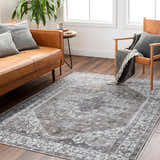 Living room scene with brown leather sofa, chair, and Athor Washable Rug in dark gray, brown, and natural gray. Roomscene-Rectangle
