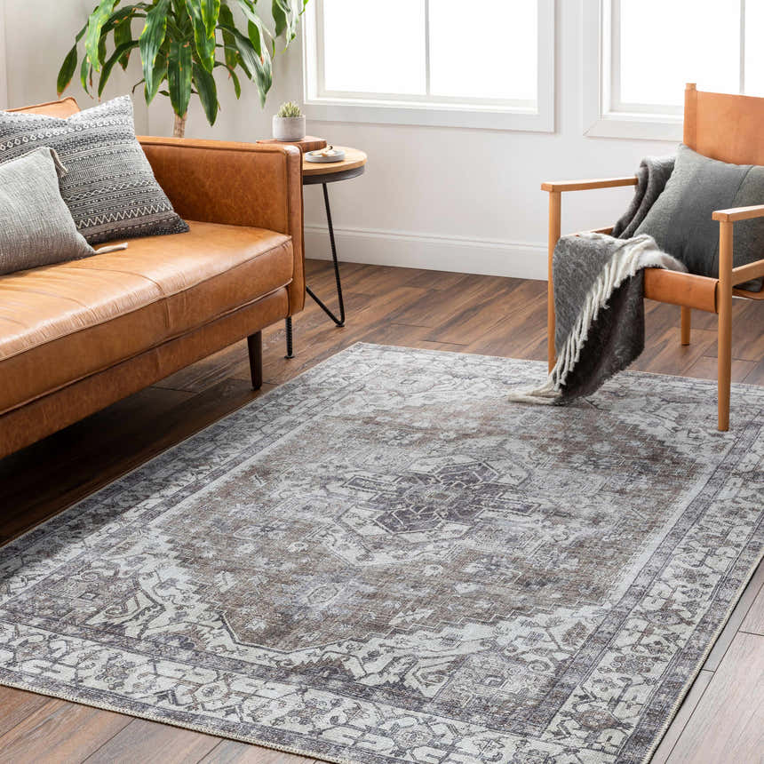 Living room scene with brown leather sofa, chair, and Athor Washable Rug in dark gray, brown, and natural gray. Roomscene-Rectangle