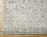 Close-up of the Pavan Beige Area Rug showing its traditional design, blue, cream, and peach colors, and soft texture. Corner