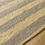 Close-up of the hand woven Ilkay Jute Area Rug. Camel and natural jute stripes show the rug's texture. Texture