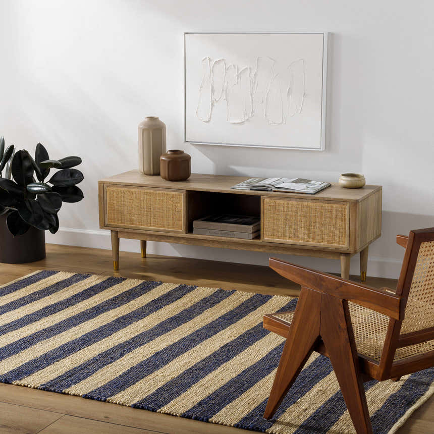 Living room scene with striped Ilkay Beige & Black Jute Area Rug, wood media console, chair, and minimalist art. Roomscene-Rectangle
