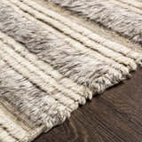 Close-up of the Saundersfoot Area Rug. Hand-knotted wool rug with a striped pattern in charcoal, gray, and light beige. Texture