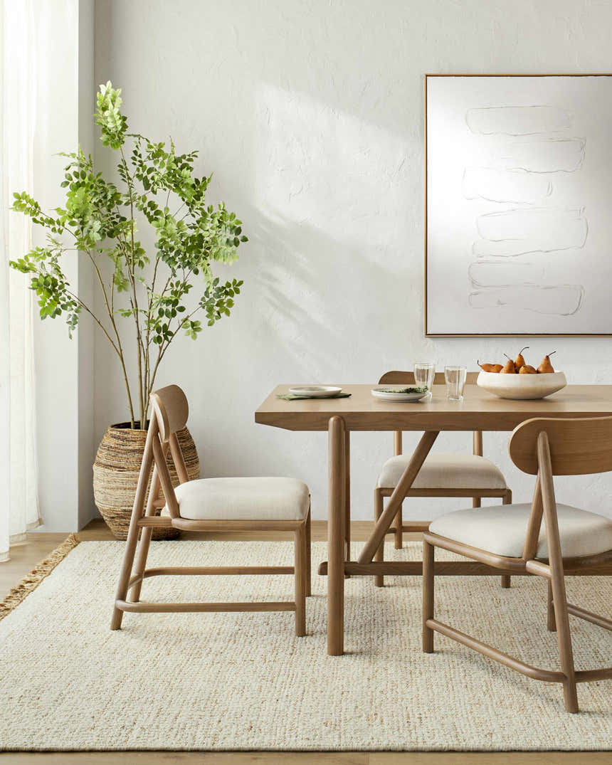 Dining room with a light wood table and the Gopi Jute&Wool Area Rug in Cream, creating a warm, neutral, Scandinavian style. Roomscene-Rectangle