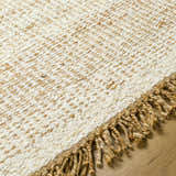 Close-up of the hand-woven Gopi Jute&Wool Area Rug in Cream, showing texture and jute fringe detail. Texture