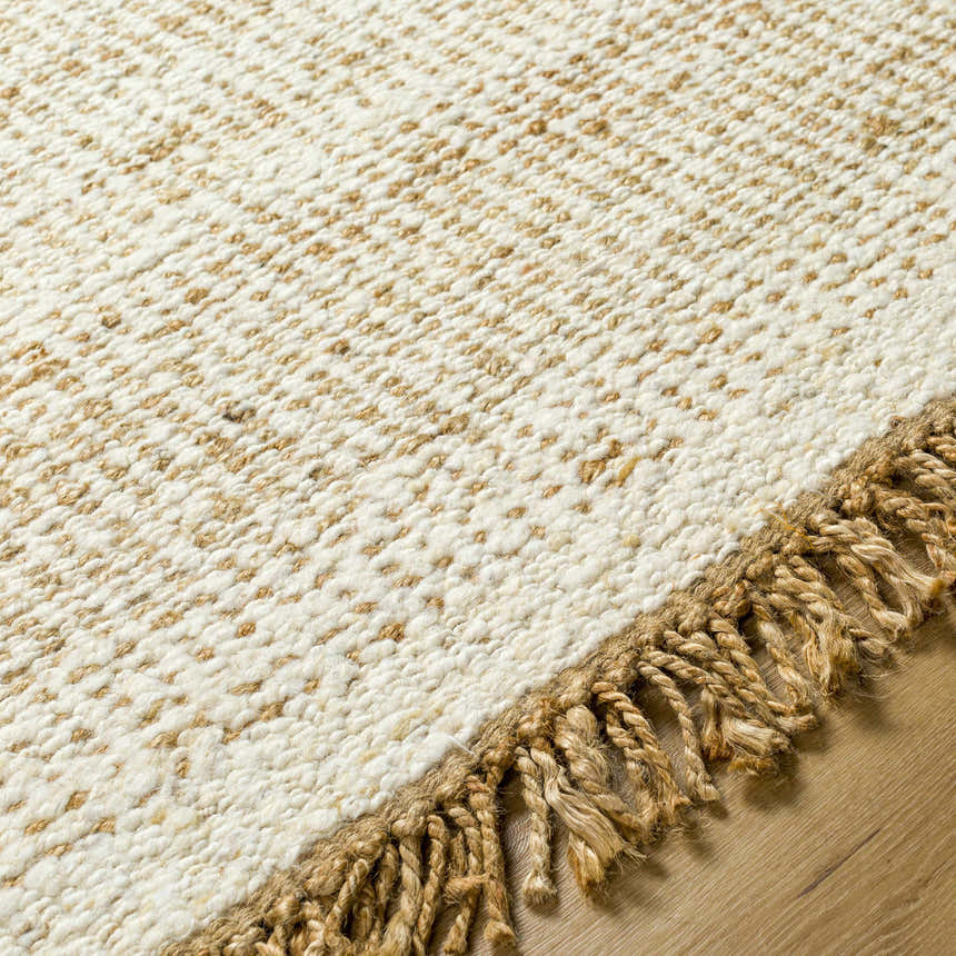 Close-up of the hand-woven Gopi Jute&Wool Area Rug in Cream, showing texture and jute fringe detail. Texture