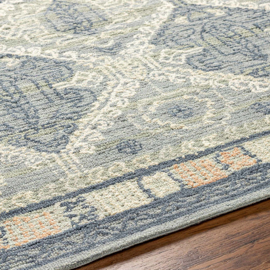 Close-up of the hand-tufted Doman Area Rug. Farmhouse style rug features a traditional pattern in gray, blue, and cream. Texture