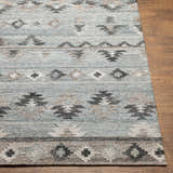 Close up of the hand woven Denna Area Rug. Southwestern design in black, blue, brown, and gray recycled PET yarn. Front