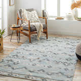 Living room scene with a blue Denna Area Rug, leather chair, and wood accents. Roomscene-Rectangle
