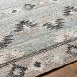 Close-up of the hand woven Denna Area Rug. Features a contemporary Southwestern pattern in black, blue, brown, and white. Texture