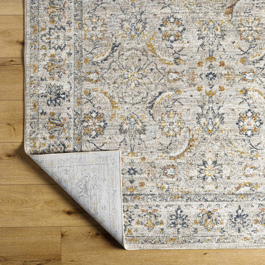 Close-up of the Jeven Gray Area Rug showing its light gray, natural gray, yellow, and navy traditional pattern. Fold