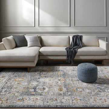 Living room scene with a light gray Karif Area Rug, beige sectional sofa, and blue ottoman. Roomscene-Rectangle