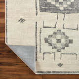 Close up of Solana Medallion Charcoal rug by Livabliss x Becki Owens. Beige rug with gray geometric medallion pattern. Fold