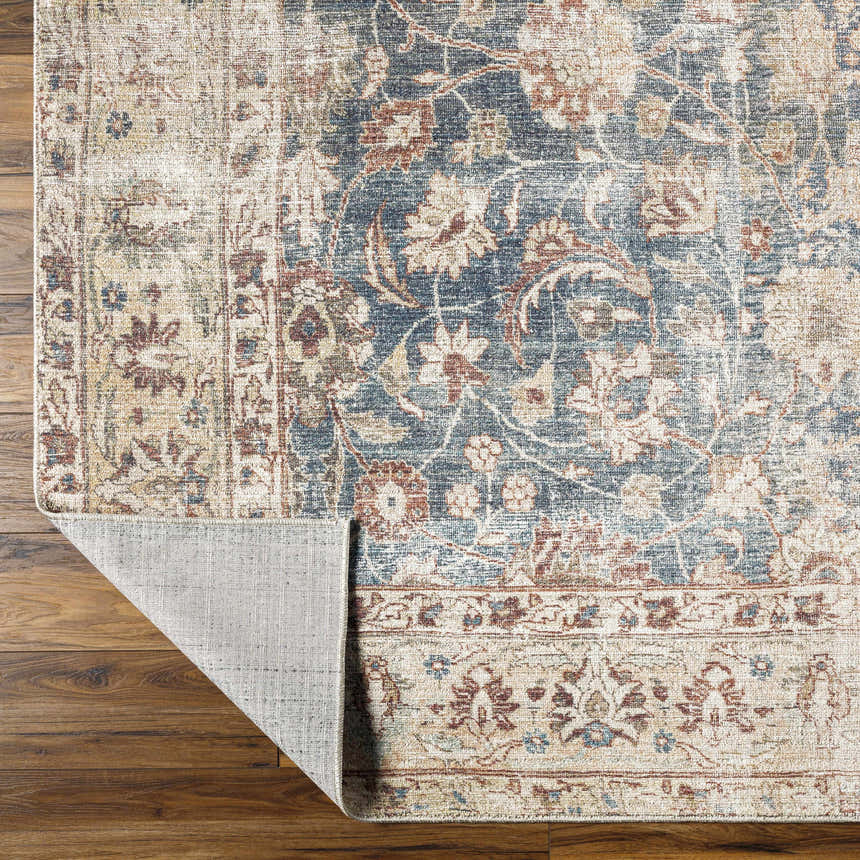 Close-up of the Marlene Damask Beige & Navy Area Rug showing its floral pattern and color variations on a wood floor. Fold
