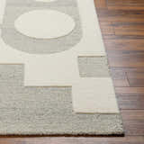 Close-up of the hand-tufted Adeja Area Rug. Contemporary geometric design in cloud gray and light gray wool on a wood floor. Front