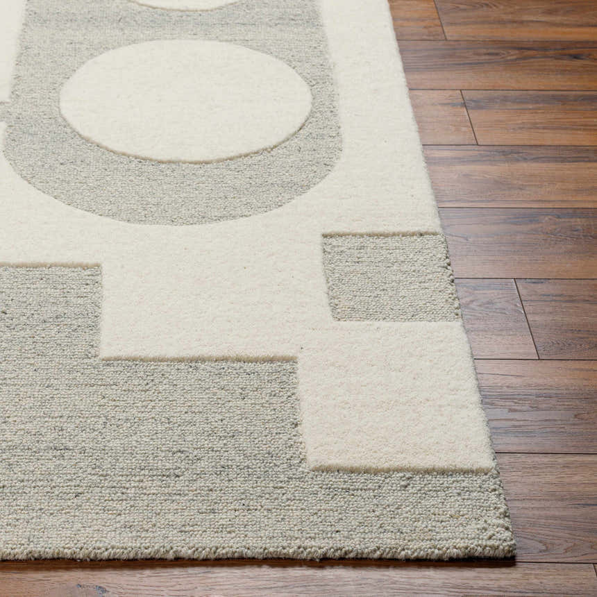 Close-up of the hand-tufted Adeja Area Rug. Contemporary geometric design in cloud gray and light gray wool on a wood floor. Front