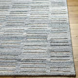 Close up of the hand-tufted Darcy Area Rug. Features a blue and white horizontal stripe pattern and a textured design. Front