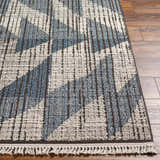 Close-up of the Zaim Area Rug showing its geometric pattern, blue and ivory colors, and textured weave on hardwood floor. Front
