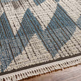 Close-up of the Zaim Area Rug. Bohemian style rug with blue and white geometric pattern and fringe detail. Texture