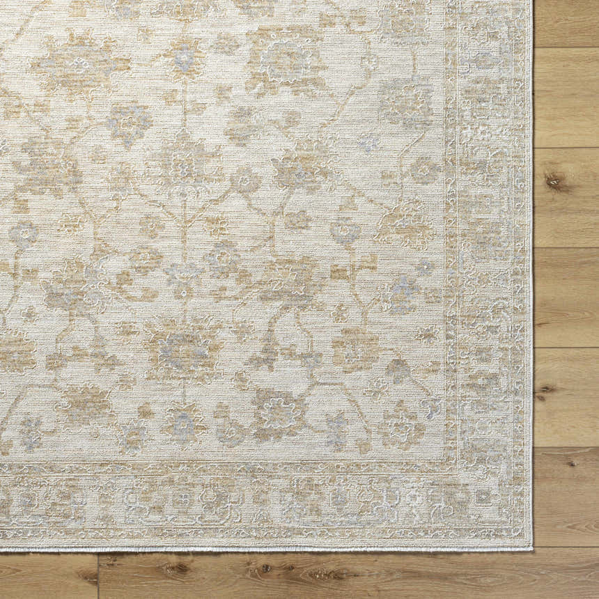 Close-up of the Sashi Tan Luxe Area Rug showing its floral, farmhouse pattern and ash, light silver, and tan colors. Corner
