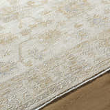 Close-up of the Sashi Tan Luxe Area Rug showcasing its traditional tan, silver, and ash floral pattern and textured weave. Texture