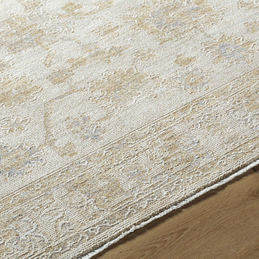 Close-up of the Sashi Tan Luxe Area Rug showcasing its traditional tan, silver, and ash floral pattern and textured weave. Texture