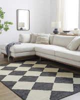 Living room scene with a beige sectional sofa and the Sondo Jet Black area rug with a checkerboard pattern. Roomscene-Rectangle