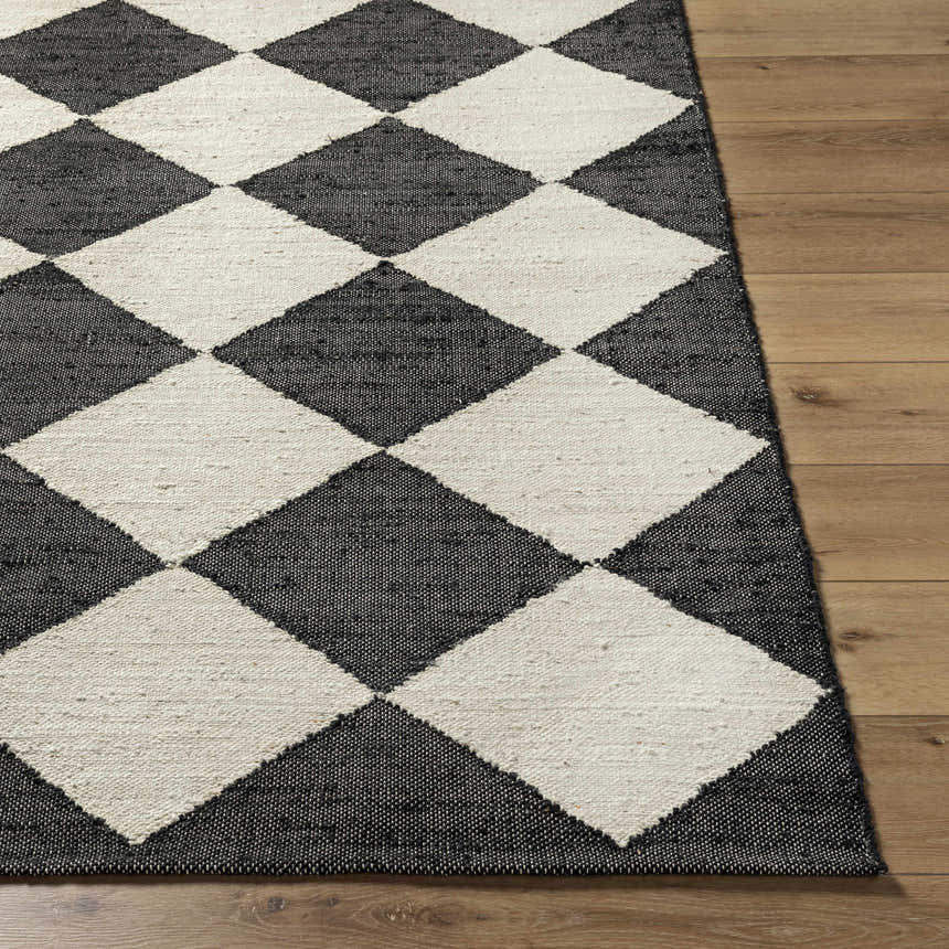 Close-up of the Sondo Jet Black Area Rug showing a large-scale black and beige diamond pattern and hand woven texture. Front