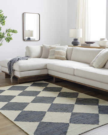 Living room scene with a modern off-white sectional sofa and the Sondo Off White Area Rug with a gray and off-white checkerboard pattern. Roomscene-Rectangle