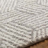 Close-up of the Mura Gray Area Rug showing its shag texture and geometric pattern in off-white, gray, and beige. Texture