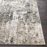 Close-up of the Schaefferstown Area Rug featuring a charcoal, gray, and light beige abstract design on dark wood floors. Front