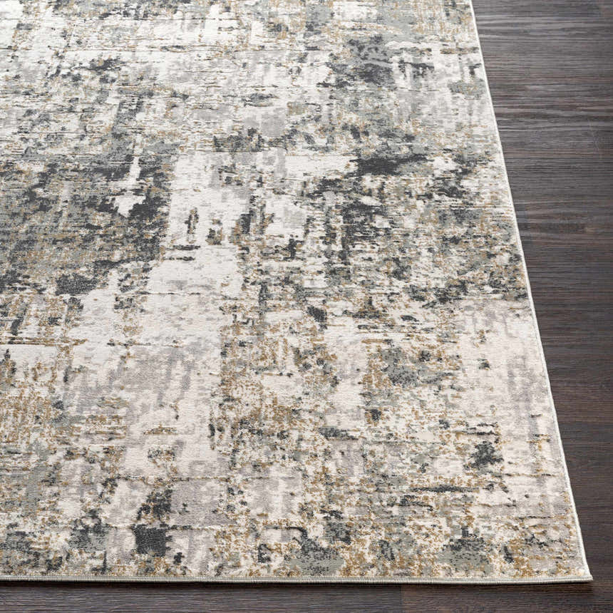 Close-up of the Schaefferstown Area Rug featuring a charcoal, gray, and light beige abstract design on dark wood floors. Front