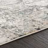 Close-up of the Schaefferstown Area Rug showing its charcoal, gray, beige, and white abstract pattern and soft texture. Texture