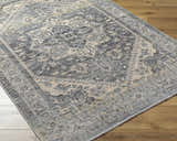 Close-up of the Ailsa Area Rug showing the dark gray, lambswool and brown traditional pattern and soft texture. Corner