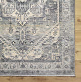 Close-up of the Ailsa Area Rug, a machine-woven polyester rug in dark gray, lambswool, and brown with a traditional pattern. Corner