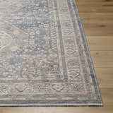 Close up of the Artan Area Rug showcasing its traditional gray, beige, and blue pattern on a wood floor. Front
