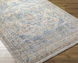 Close-up of the Bora Area Rug on wood floor. Traditional rug design in camel, copper, dark gray, and lambswool. Corner