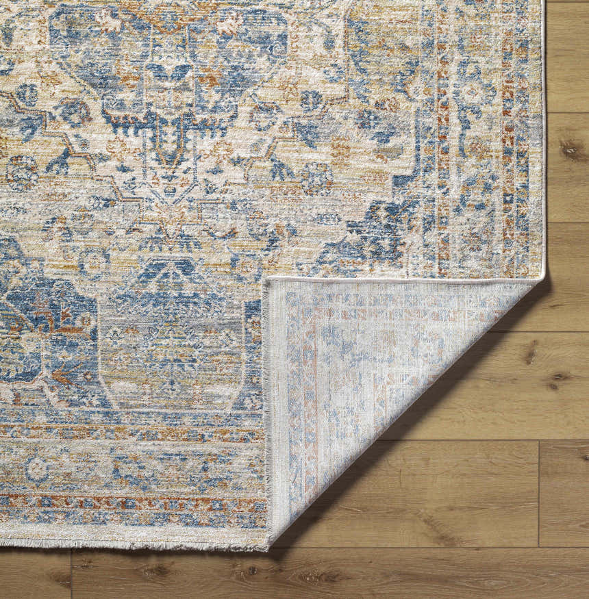Close-up of the Bora Area Rug in camel, copper, and blue, showing the traditional pattern and machine-woven construction. Fold