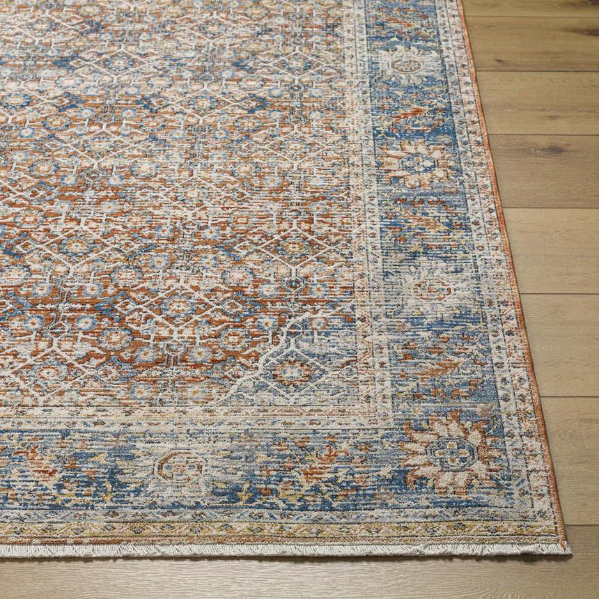 Close-up of the clay, copper, and denim Dalit Area Rug, showcasing its traditional pattern and soft texture. Front