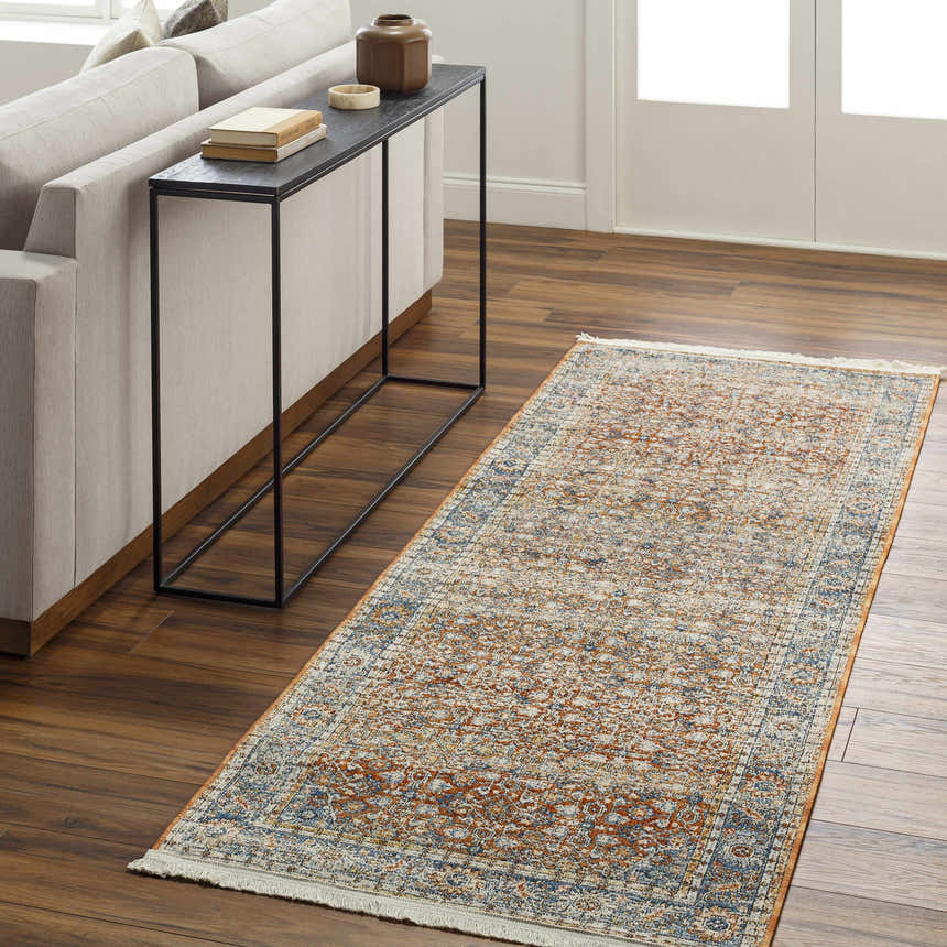 Living room scene with a clay, copper, and denim Dalit Area Rug runner, light sofa, and dark console table. Roomscene-Runner