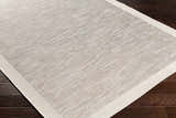 Close-up of the Escalon Area Rug. Cream and taupe striped design, machine woven texture, and a solid cream border. Corner
