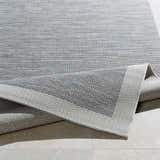 Close-up of the Escalon Area Rug, a cream and taupe polypropylene rug with a solid and striped contemporary design. Fold