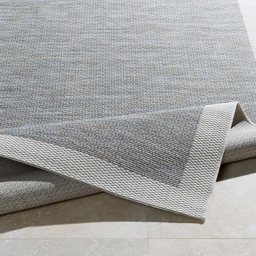 Close-up of the Escalon Area Rug, a cream and taupe polypropylene rug with a solid and striped contemporary design. Fold