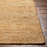 Close-up of the hand woven texture and natural jute color of the Olof Hand Woven Jute Rug on dark wood floors. Front