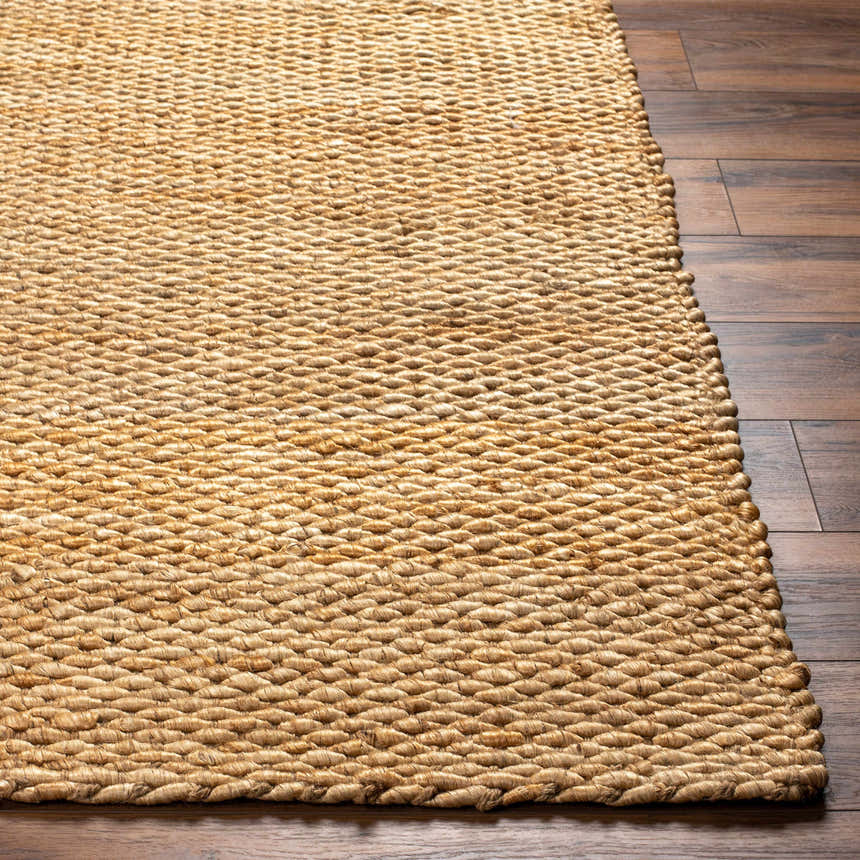 Close-up of the hand woven texture and natural jute color of the Olof Hand Woven Jute Rug on dark wood floors. Front
