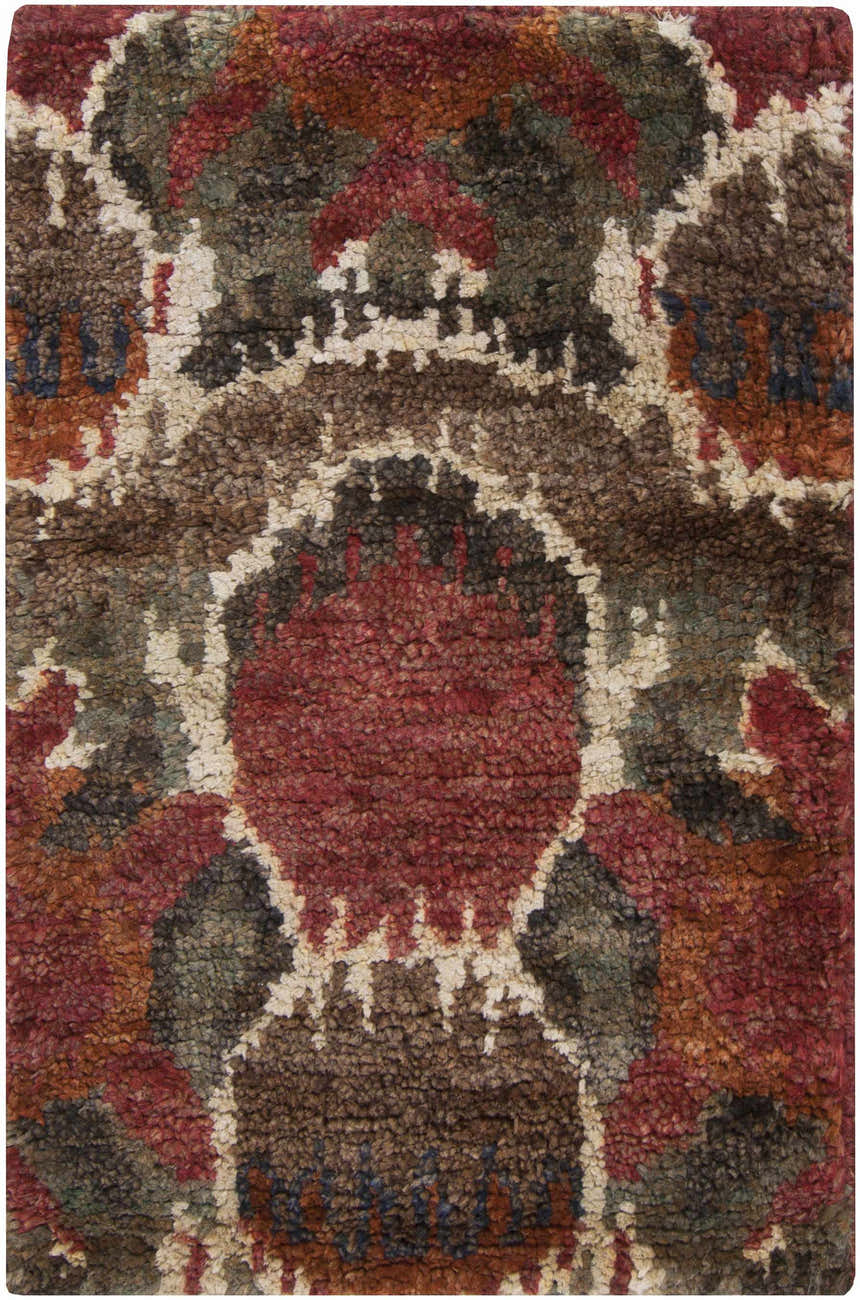 Close-up of the Scotia Brown Ikat Jute Rug, featuring a bohemian design with red, brown, cream, and sage colors. Hand-knotted texture. Design-Rectangle-23