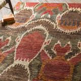 Close up of Scotia Brown Ikat Jute Rug, featuring red, brown, and beige bohemian pattern and textured jute fibers. Styleshot