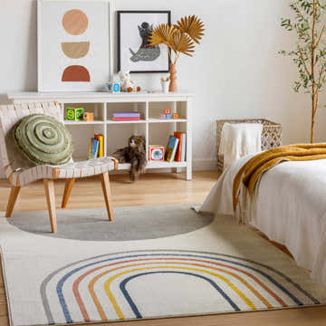 Kids bedroom with Adla Area Rug, featuring a colorful rainbow design, chair, and white shelving. Roomscene-Rectangle
