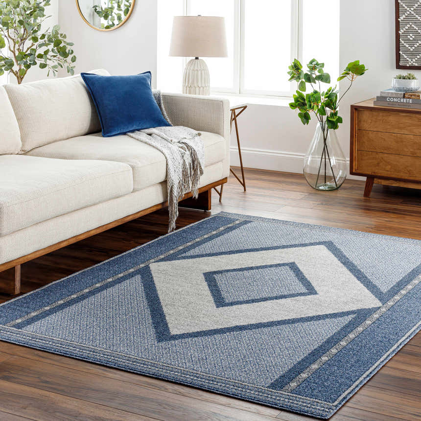 Living room scene with a blue and gray Onan Area Rug, white sofa, and wood accents. Roomscene-Rectangle